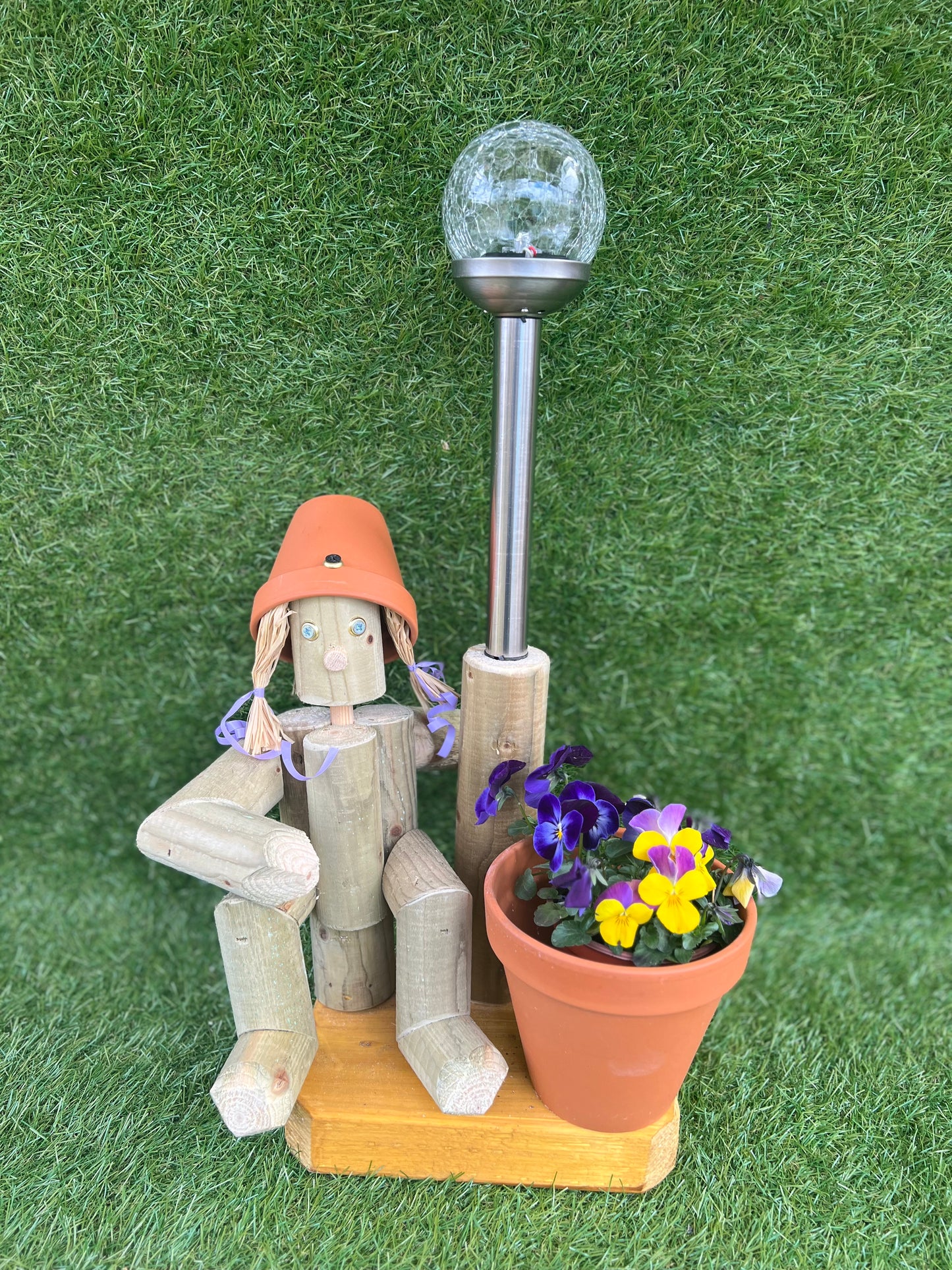 Small, sitting girl holding a pot with solar light