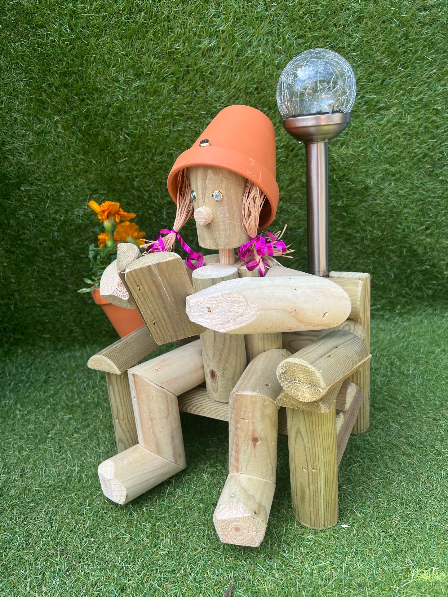 A girl sitting on a chair reading a book with a solar lamp