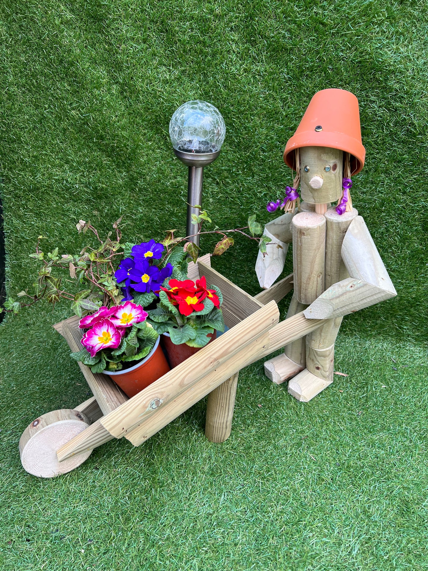 Girl or boy with wheelbarrow with a solar lamp