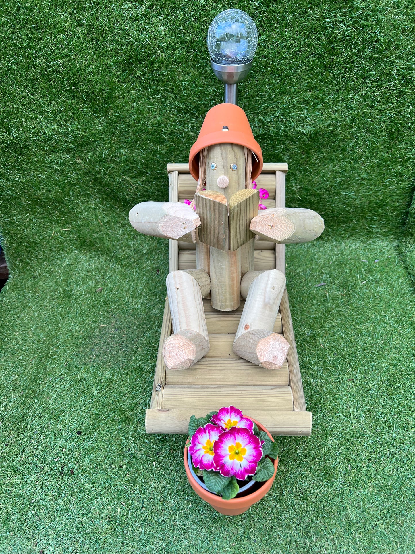 Girl on a deckchair reading a book with a solar lamp