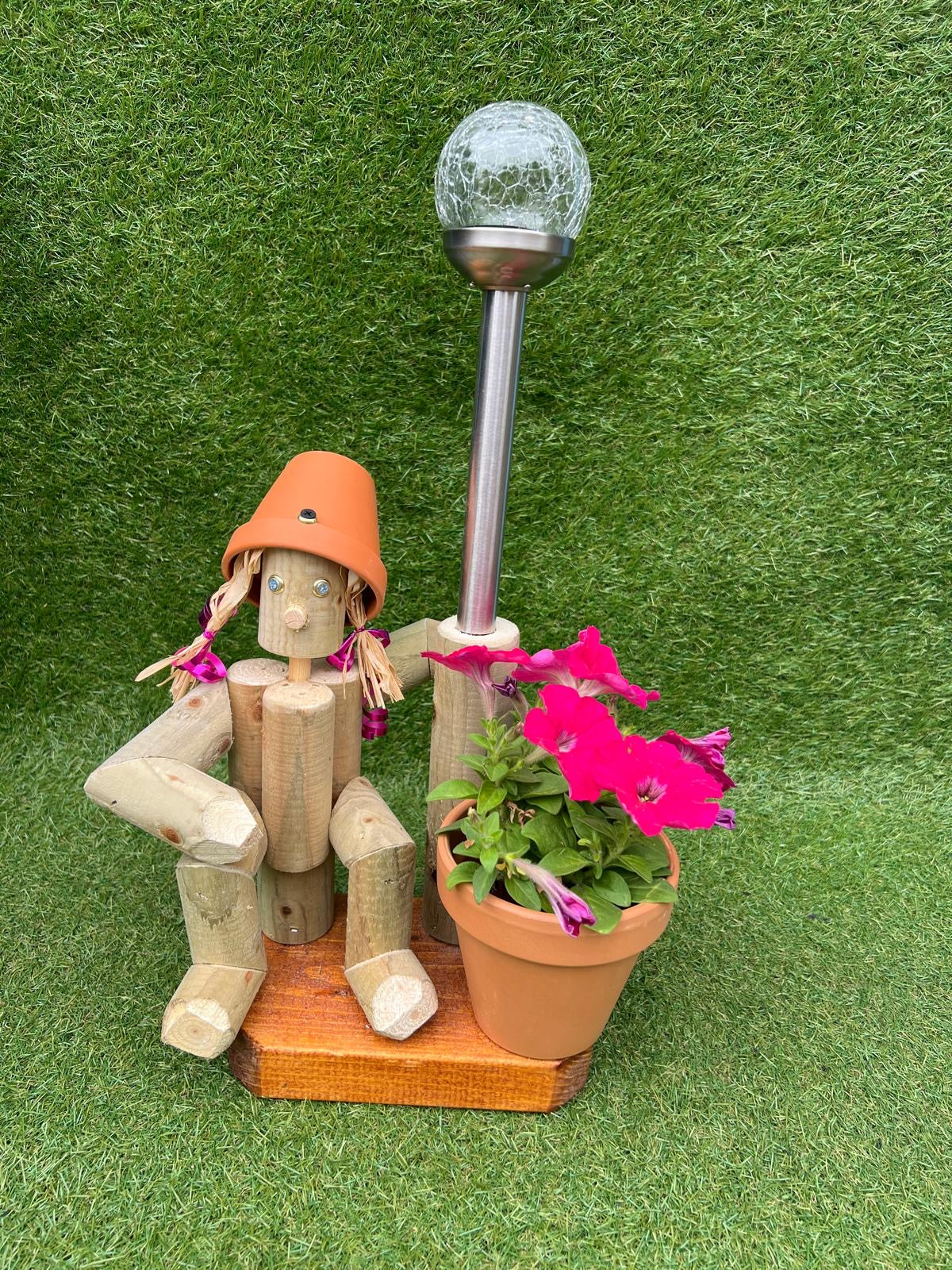 Small, sitting girl holding a pot with solar light