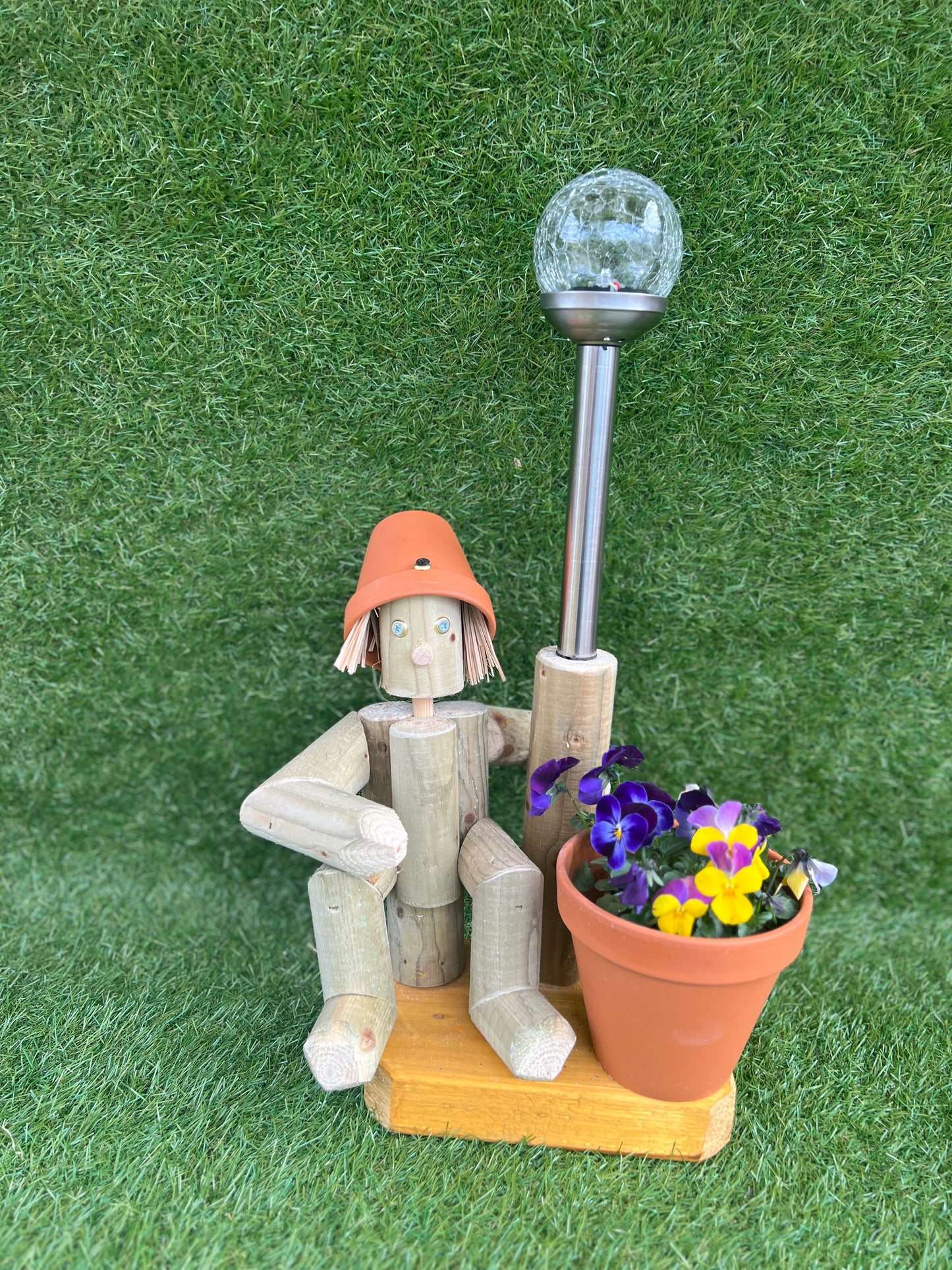 Small, sitting girl holding a pot with solar light