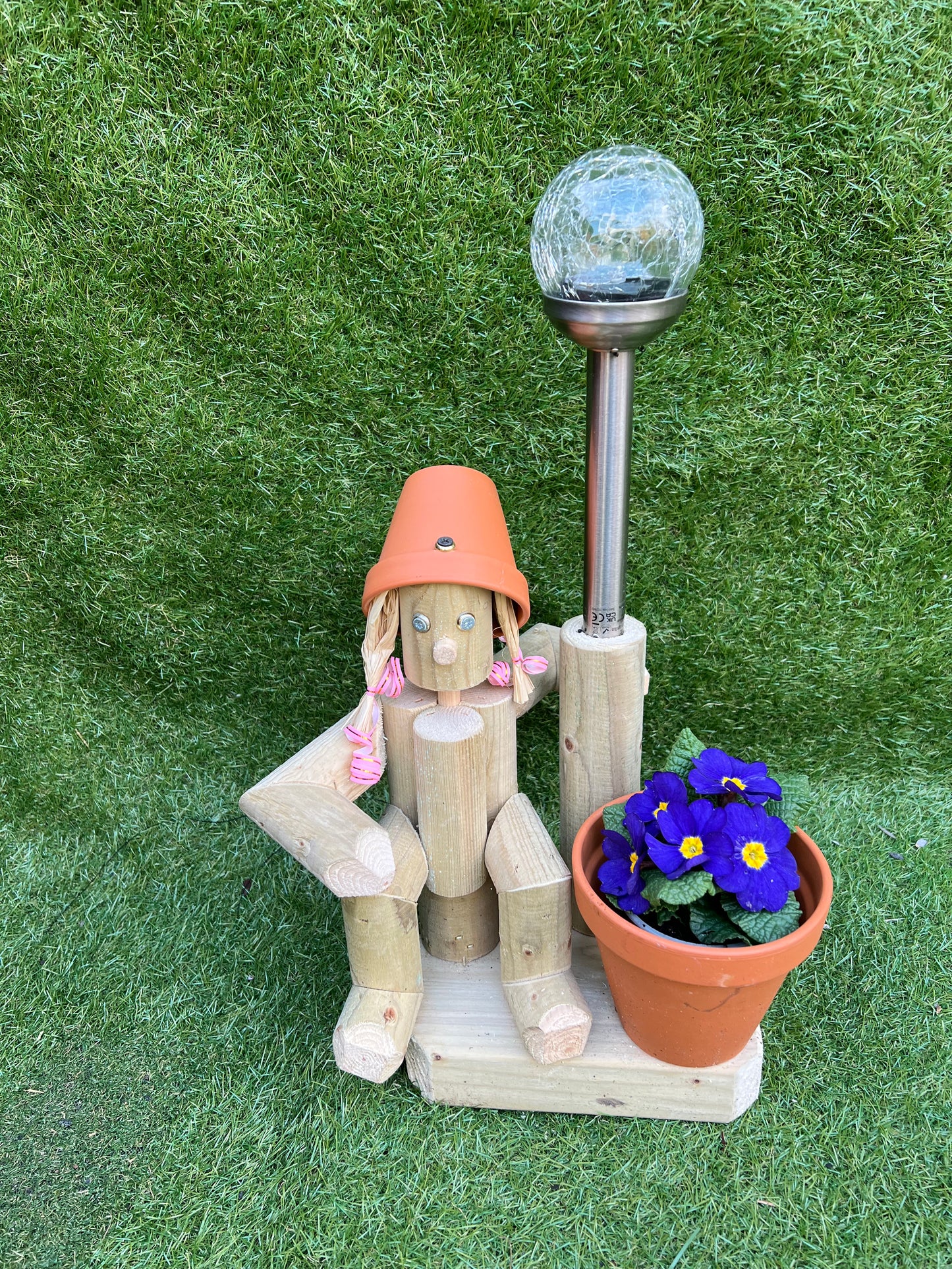 Small, sitting girl holding a pot with solar light